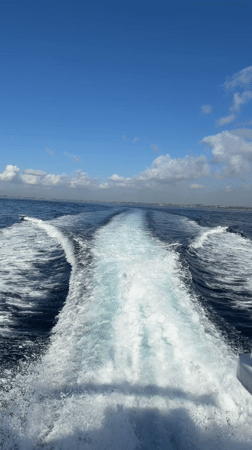 Boat creates wake trail in ocean near Sukawati, Indonesia