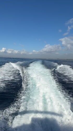 Boat creates wake trail in ocean near Sukawati, Indonesia