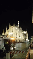 Night street sweeping in front of the illuminated Milan Duomo