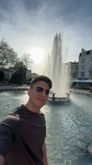 Tourist takes selfies at Plovdiv fountains during afternoon visit