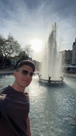 Tourist takes selfies at Plovdiv fountains during afternoon visit