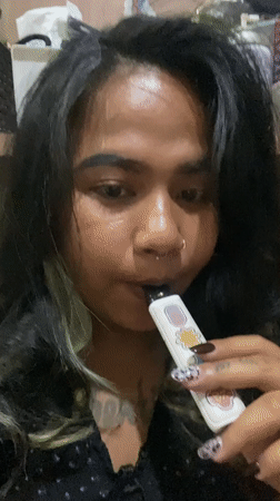 Tattooed customer vapes while getting nails done in Kuta salon