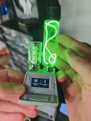 Person demonstrates miniature computer device with glowing vials in Tyumen
