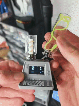 Person demonstrates miniature computer device with glowing vials in Tyumen