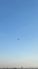 Dark smoke rises over Kepez as aircraft circle above