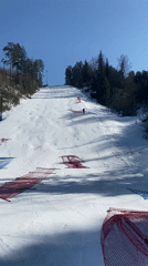 Skier descends marked slope in sunny Ol'khovskoye, Russia