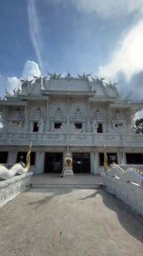 Exploring a white temple's ornate architecture in Thep Krasatti