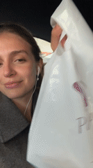 Woman with earphones seated in car backseat, Tbilisi