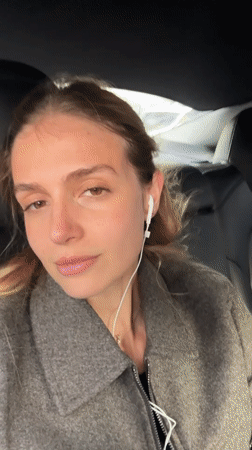 Woman with earphones seated in car backseat, Tbilisi