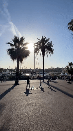 Bubble performer entertains children at Barcelona's Port Vell harbor