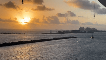 Cruise ship sails near port during sunset
