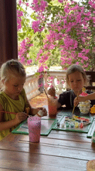 Children paint ceramic figures at outdoor table in Vietnam