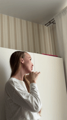 Woman in white shirt observed near striped wall in Sirius