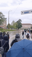 Pedestrians with umbrellas navigate wet streets in Gabrovo