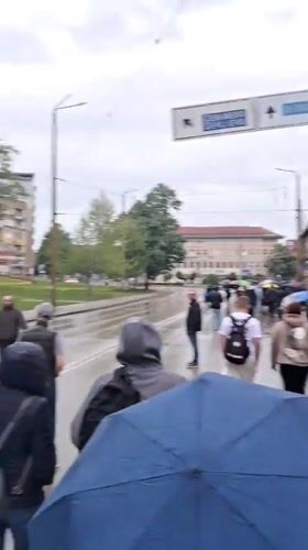 Pedestrians with umbrellas navigate wet streets in Gabrovo
