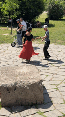 Couple dances hand-in-hand in sunny Milan park