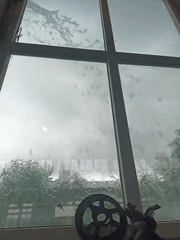 Rain streaks across window, obscuring outdoor view