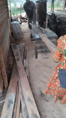 Wood worker operates table saw at outdoor processing site