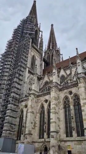 Renovation scaffolding visible on Regensburg Cathedral amid tourist activity