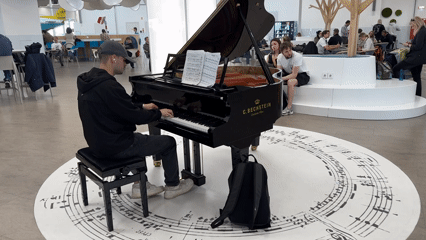 Young pianist performs on grand piano in Budapest public space