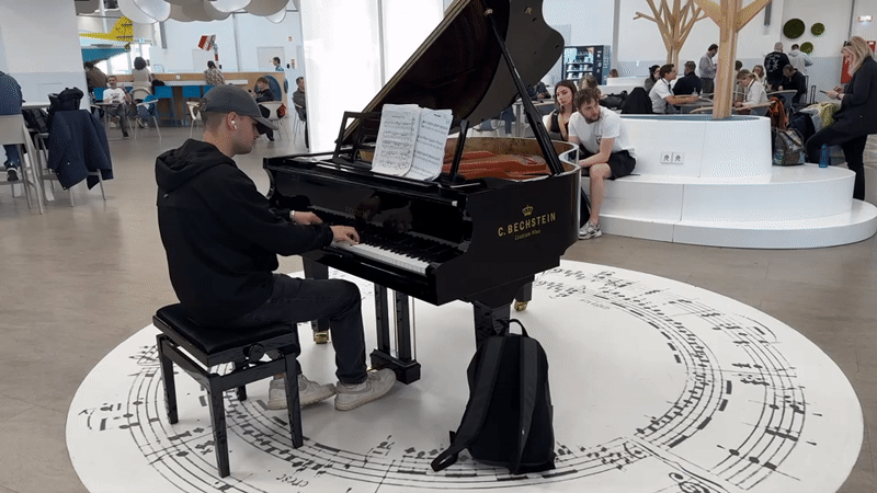 Young pianist performs on grand piano in Budapest public space