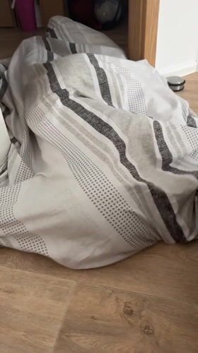 Bedroom in Eberswalde: striped bedding on bed, duvet on floor