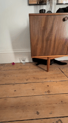 Black cat spotted hiding under wooden cabinet in London