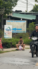 Young boy plays with scooter, bicycle on Đà Nẵng street