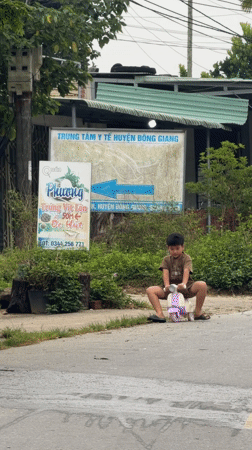 Young boy plays with scooter, bicycle on Đà Nẵng street