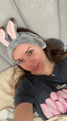 Woman in bunny ears relaxes on couch in Batumi