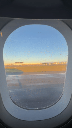 Passenger films golden hour airport view from plane window