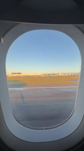Passenger films golden hour airport view from plane window