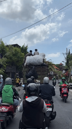 Waste collection truck with workers observed in Mengwi traffic