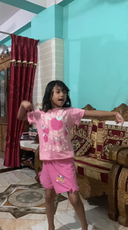 A Dhaka morning at home: a cat, a kid, and the city outside