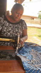 Woman operates sewing machine in outdoor workspace, Maigizo Nigeria
