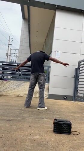 Man performs street dance outside building in Bukuru