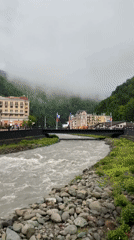 Fast-flowing river observed through misty mountain town Estosadok