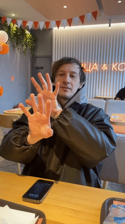 Man performs magic trick at cafe table in Murino