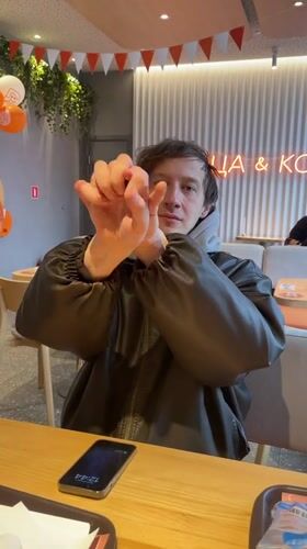 Man performs magic trick at cafe table in Murino
