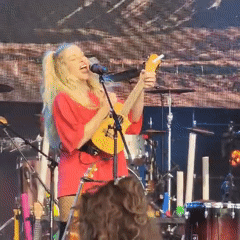 Two musicians perform live on stage with ukulele and bass