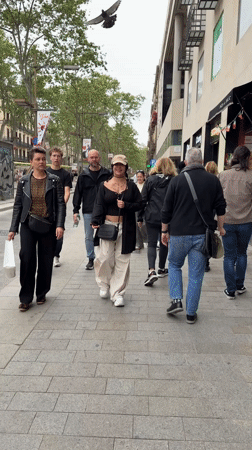 Pedestrians captured walking busy Barcelona street scene Sunday afternoon