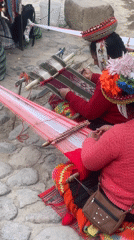 Indigenous women weave fabric on Ollantaytambo sidewalk