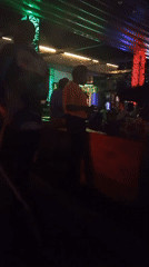 Evening social gathering documented at illuminated bar venue in Howayi