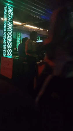 Evening social gathering documented at illuminated bar venue in Howayi