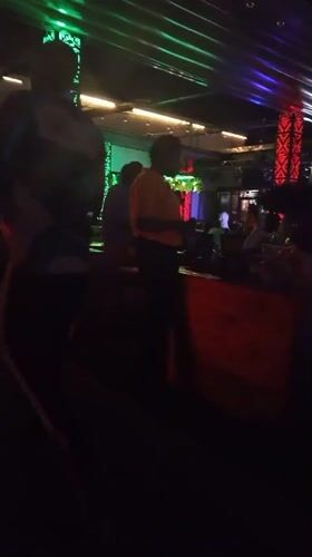 Evening social gathering documented at illuminated bar venue in Howayi