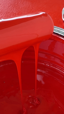 Person handles red paint equipment in Tinaquillo, Venezuela