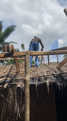 Person performs rooftop work on building in Nguzu Edda