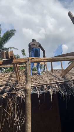Person performs rooftop work on building in Nguzu Edda