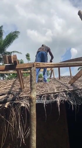 Person performs rooftop work on building in Nguzu Edda