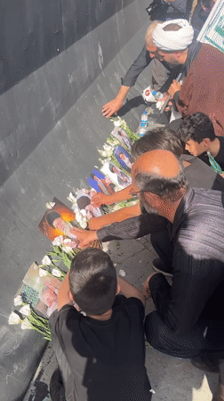 Flowers, portraits, and prayer at a Tehran memorial gathering